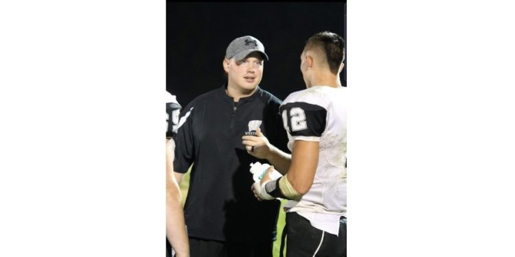 Westside head coach Tyler Dunigon (left) talks with a player during a game last season in Clear Fork. (Photo Credit: Jim Cook)