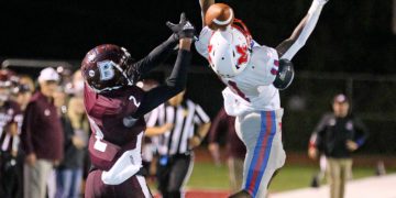 (Brad Davis/For LootPress) Woodrow Wilson receiver Keynan Cook stays focused on a deep ball as it bounces off Morgantown defender Bobby Powell and eventually into Cook's hands for a touchdown Friday night in Beckley.