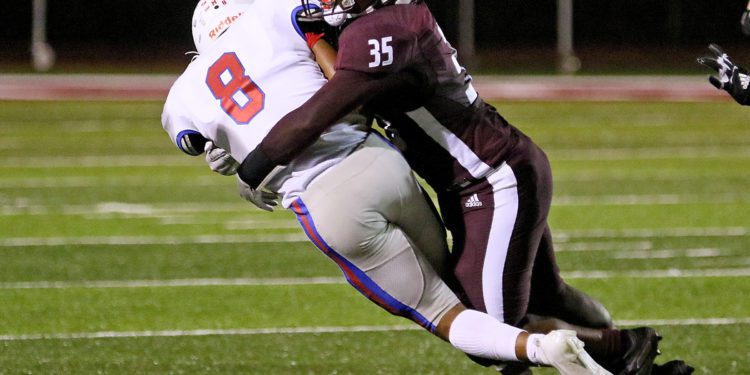 (Brad Davis/For LootPress) Woodrow Wilson's Matthew Moore makes a solid tackle on Morgantown ball carrier Brodrick Washington Friday night in Beckley.