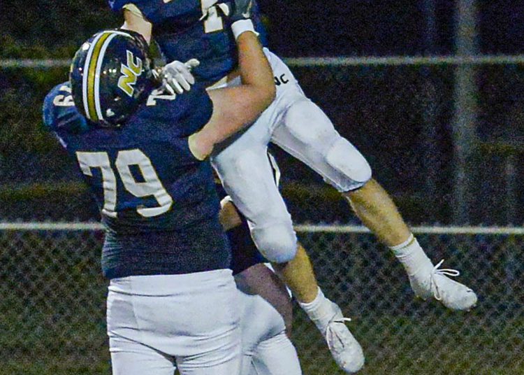 Nicholas County’s Levi Hellems picks up RB Alex Pritt after scoring a TD run against Wyoming East during Friday action in Summersville. (F. Brian Ferguson/Lootpress).