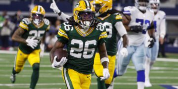 Green Bay Packers safety Darnell Savage (26) runs with the ball after making an interception on a pass by Dallas Cowboys quarterback Dak Prescott during the first half of an NFL football game, Sunday, Jan. 14, 2024, in Arlington, Texas. Savage scored on the interception return. (AP Photo/Michael Ainsworth)