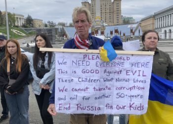 Ryan Wesley Routh holds up a banner during a rally in central Kyiv, Ukraine on Saturday April 30, 2022. (AP Photo/Alex Babenko)