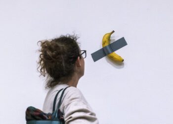 File - A woman looks at artist Maurizio Cattelan's piece of art "Comedian" during an auction preview at Sotheby's in New York, Monday, Nov. 11, 2024. (AP Photo/Eduardo Munoz Alvarez, File)