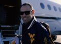 WVU AD Wren Baker boarding plane bound for Anniston, AL | (WVU Football/X)