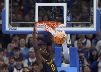 West Virginia center Eduardo Andre dunks the ball during the first half of an NCAA college basketball game against Kansas, Tuesday, Dec. 31, 2024, in Lawrence, Kan. (AP Photo/Charlie Riedel)