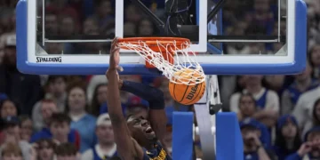 West Virginia center Eduardo Andre dunks the ball during the first half of an NCAA college basketball game against Kansas, Tuesday, Dec. 31, 2024, in Lawrence, Kan. (AP Photo/Charlie Riedel)