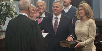 North Carolina Gov. Josh Stein, center, takes the oath of office from state Supreme Court Chief Justice Paul Newby, placing his hand on the Hebrew Bible held by Stein's wife, Anna, in the old Senate chamber of the 1840 Capitol Building in Raleigh, N.C. on Wednesday, Jan. 1 ,2025 (AP Photo/Gary D. Robertson)