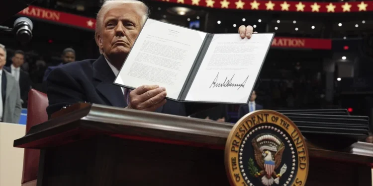 President Donald Trump signs an executive order as he attends an indoor Presidential Inauguration parade event at Capital One Arena, Monday, Jan. 20, 2025, in Washington. (AP Photo/Evan Vucci)