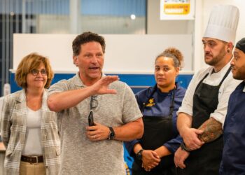 Prior to lunch service at the Mountainlair, Travis Young (center), senior president of education for Elior North America, provides an update to employees with WVU Hospitality Group, the new dining partnership between the University and Elior Collegiate Dining. (WVU Photo/Savanna Leech)