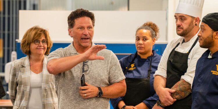 Prior to lunch service at the Mountainlair, Travis Young (center), senior president of education for Elior North America, provides an update to employees with WVU Hospitality Group, the new dining partnership between the University and Elior Collegiate Dining. (WVU Photo/Savanna Leech)